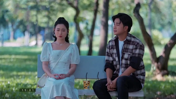A man and a woman sit on a park bench in "Gia Vị Tình Thâm".