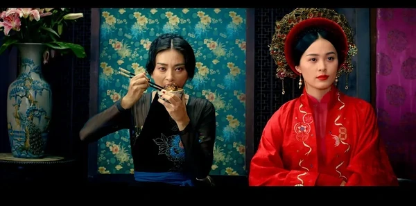 Dining scene from "Tấm Cám: Chuyện chưa kể" with two women in traditional attire.