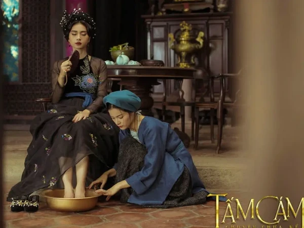 Scene from "Tấm Cám: Chuyện chưa kể" showing a woman having her feet washed.