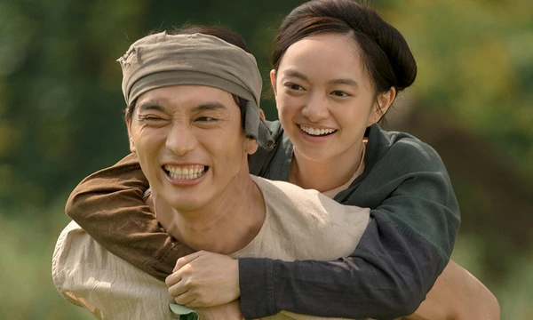 In The Last Wife, a joyful moment as a man gives a piggyback ride to a woman in a rural setting.