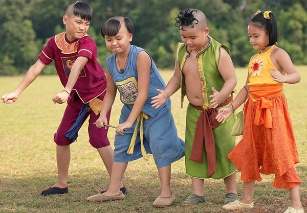 Four kids in vibrant clothes play on a field in "Trạng Tí".